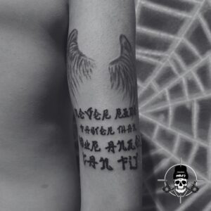 random text tattoo with wings